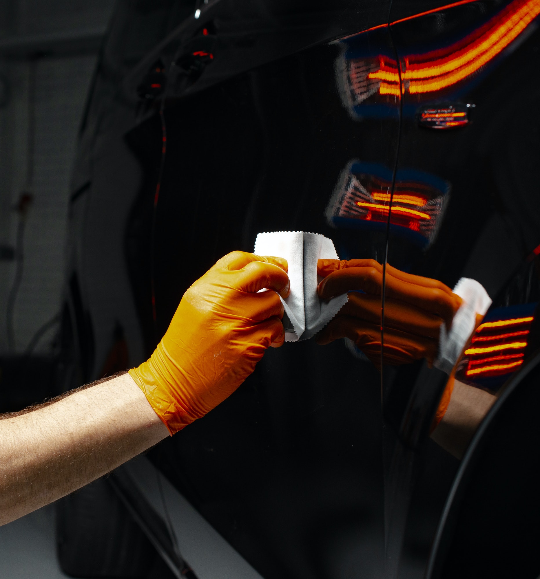 Car polish wax worker hands polishing car